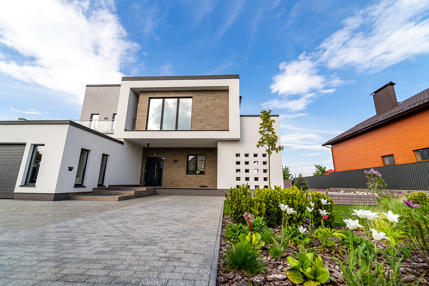 Luxury house with garage. Blue sky above. Nobody in the yard. Modern architecture. Cozy and modern house. Modern architecture.